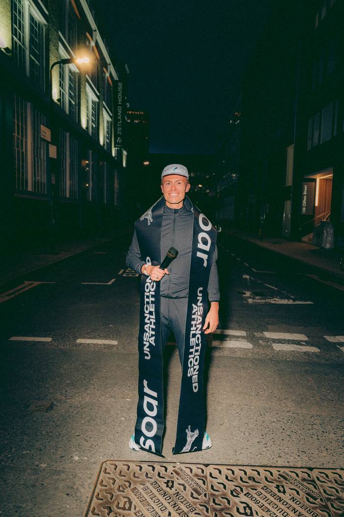 Lloyd wearing a SOAR sash at a street race at night